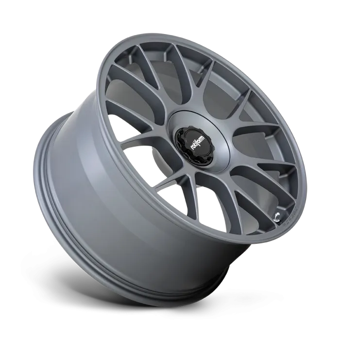 A matte gray car wheel rim with seven pairs of spokes, displaying the text "rotiform" in white on a black center cap, isolated against a white and black gradient background.
