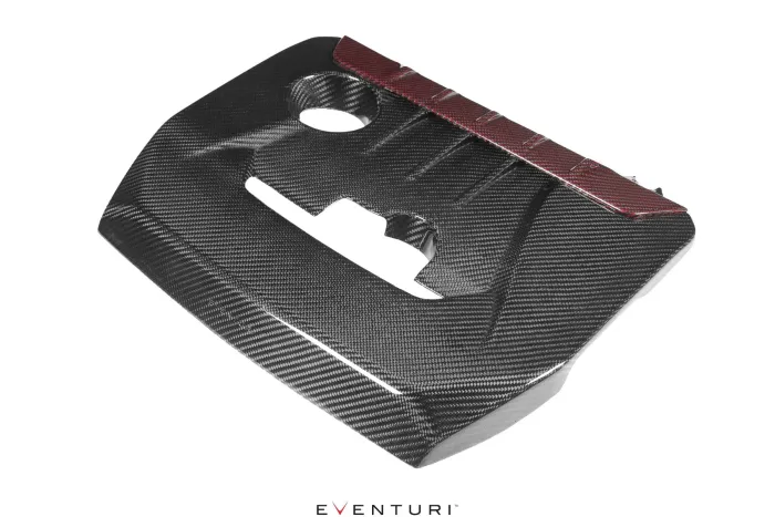 Black carbon fiber engine cover with a red accent across the top, featuring cutouts for functional components, displayed against a white background. Text: “EVENTURI” at the bottom center.