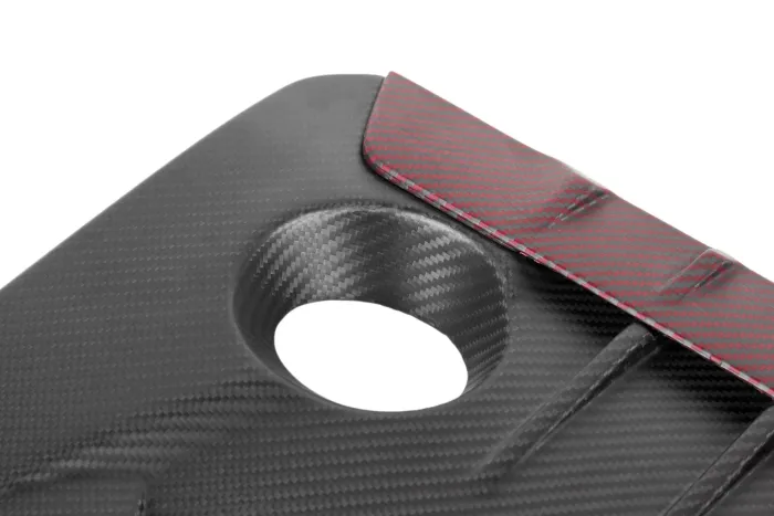 A carbon fiber panel with a circular cutout and red accent edge detailing, displayed against a white background.