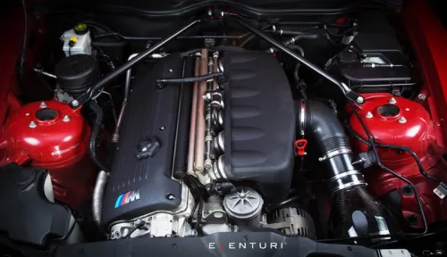 An automobile engine sits in a red-painted engine bay, featuring an Eventuri intake system on the right and a strut bar across the top. The text "EVENTURI" is visible at the bottom.