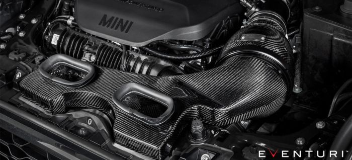 Carbon fiber air intake system situated within a MINI engine bay, surrounded by polished engine components and wiring; the word "EVENTURI™" appears in the bottom corner.