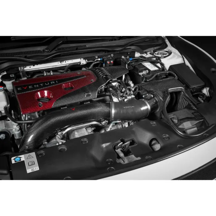 A car engine bay features a carbon fiber intake system labeled "EVENTURI," surrounded by various engine components and a red engine cover. The context is the raised hood of the vehicle.