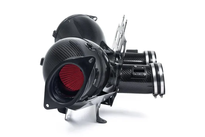 A pair of black carbon fiber air intake assemblies featuring red cone filters are positioned on a white background, highlighting their sophisticated design and mechanical purpose.