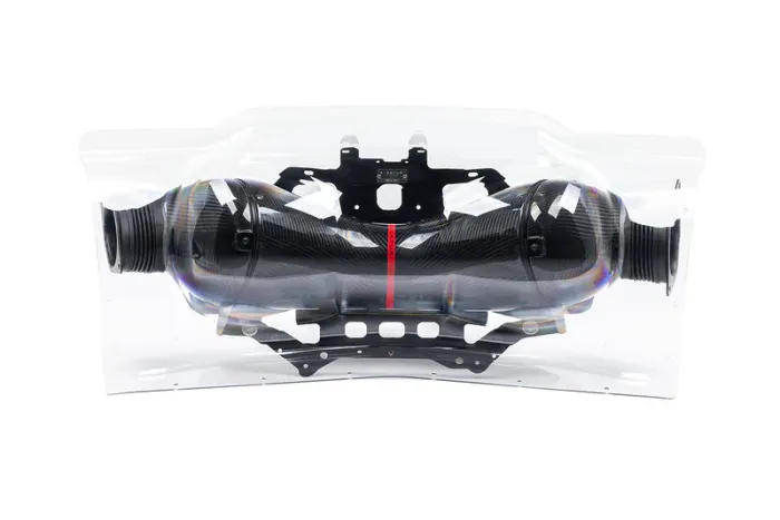 Carbon fiber air intake system encased in a transparent plastic bag, placed on a white background.