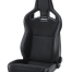 A black, padded racing seat with "RECARO" branding, featuring high sides and cutouts near the headrest, positioned in an isolated, white background.