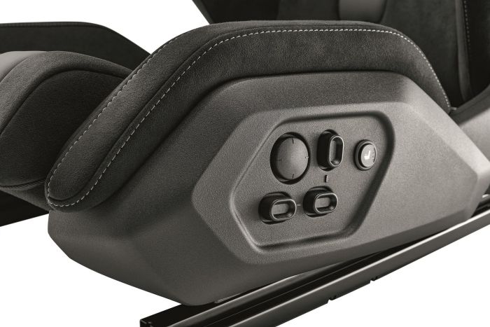 A car seat panel with buttons and knobs for adjustments, including a seat heater, set against a background of black, cushioned material with white stitching.