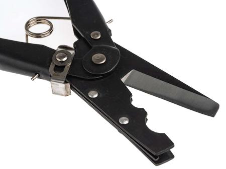 A pair of black, metal crimping pliers with cutting blades, partially open, lying on a white surface. A coiled spring is visible near the handles, indicating its functionality.