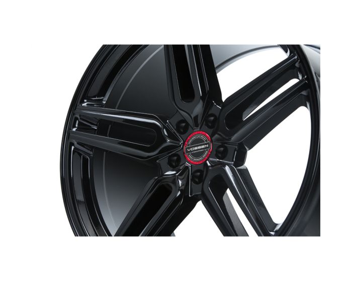 A black Vossen wheel with five spokes features a glossy finish, shown in close-up against a white background. Center cap text reads: "VOSSEN FORGED ENGINEERED ART."