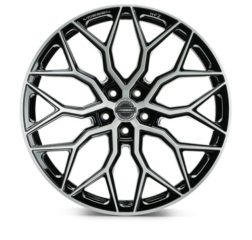 A black and silver alloy wheel displays a complex, geometric spoke pattern. Text includes "VOSSEN" and "HF-2" on the wheel rim. The background is plain white.