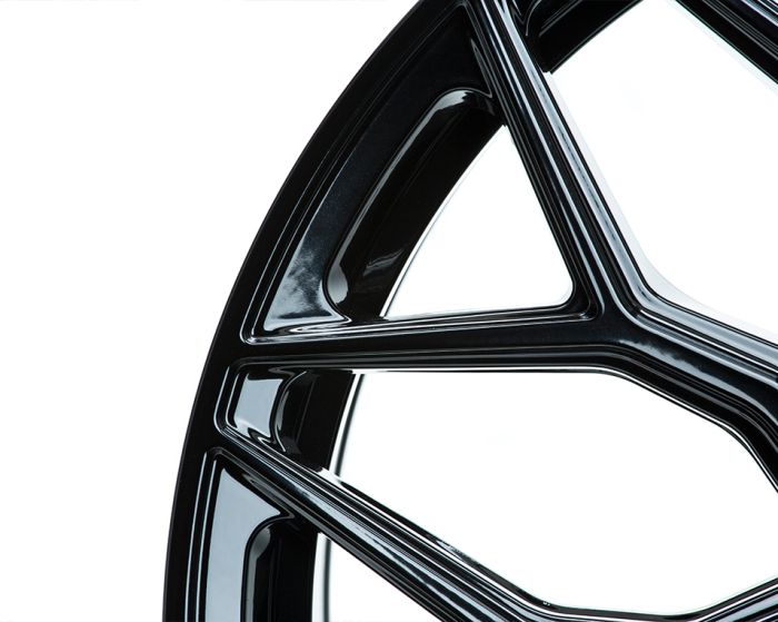 Curved black metal frame forms a geometric pattern against a plain white background, showcasing smooth, glossy surfaces with intersecting lines and triangular shapes.