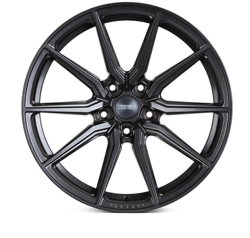 A black alloy wheel with multi-spoke design lies against a plain white background. Text reads "Vossen Forged" at center and "VF" on the rim.