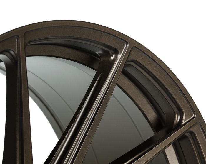 A metallic bronze car wheel rim with angular spokes, shown in partial close-up, highlighting its sleek, glossy finish against a plain white background.