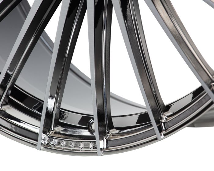 A glossy chrome alloy wheel with sleek, curved spokes interlocking in a close-up view, highlighting the metallic finish in a well-lit studio setting.