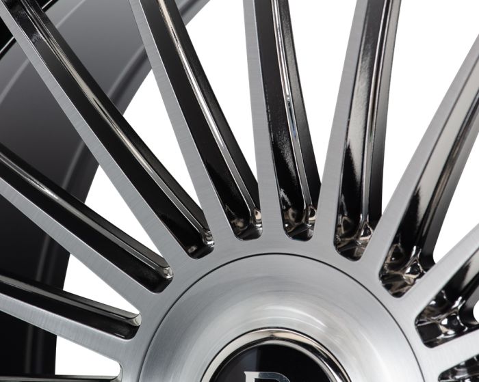 A close-up view of a car wheel rim features sleek, shiny metal spokes radiating from the center. The reflective surface is set against a white background.