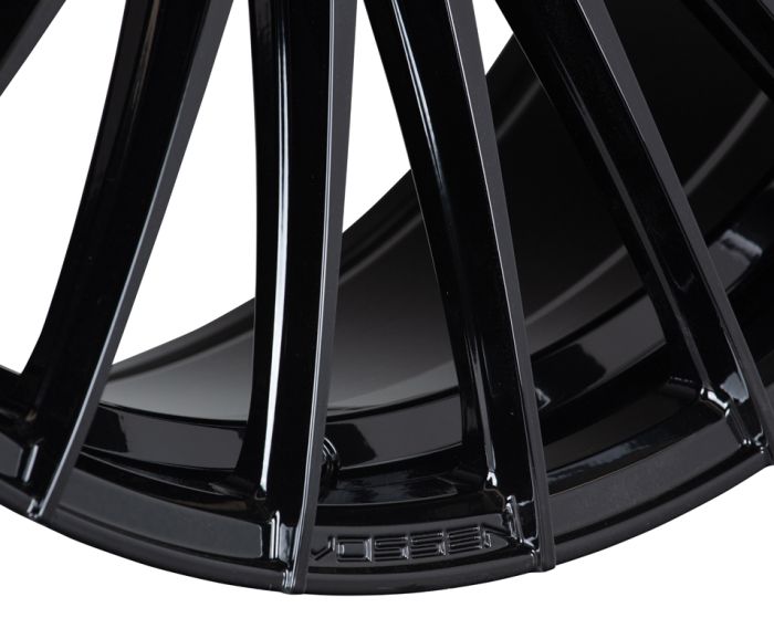 A glossy black car wheel rim with multiple spokes is prominently displayed, showcasing its sleek design and reflecting light. The brand name “VOSSEN” is engraved at the base.