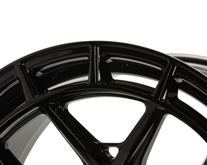 A glossy black car wheel rim with a sleek, modern design extends partially into view, against a plain white background. The rim features multiple spokes and curved patterns.