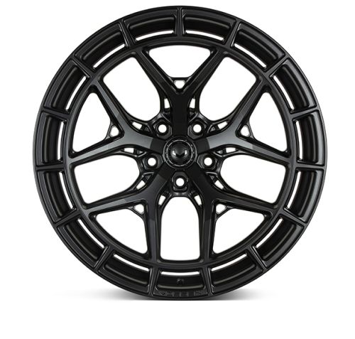 A black, intricately designed car wheel rim with multiple slim, interlocking spokes rests against a plain white background, showcasing its detailed structure and craftsmanship.