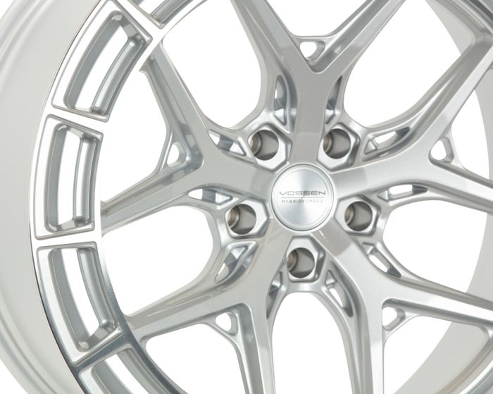 A silver car wheel rim with a complex, multi-spoke design. Center marked "VOSSEN HYBRID FORGED," displayed against a plain white background.