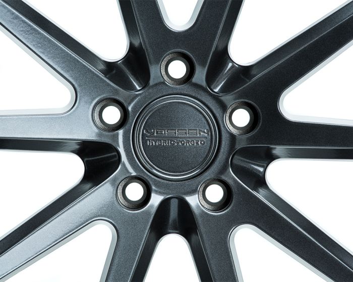 A sleek metallic wheel rim features stylized angular spokes radiating from the center. Text on the hub reads "VOSSEN HYBRID FORGED." Positioned against a plain white background.