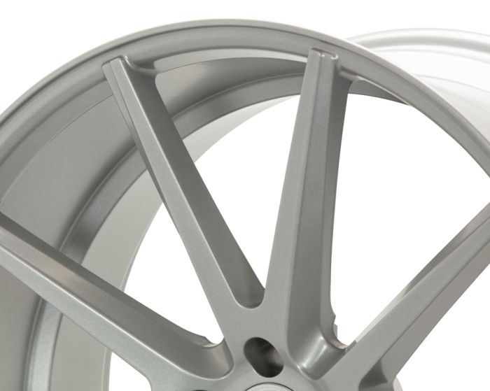 A close-up view of a metallic car wheel rim with five sleek, angular spokes, set against a plain white background.