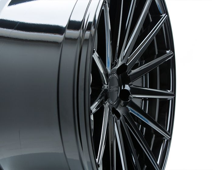 A glossy black alloy wheel with multiple spokes, resting upright against a plain white background. The center of the wheel features the text "VERSUS XF-9 539/991".